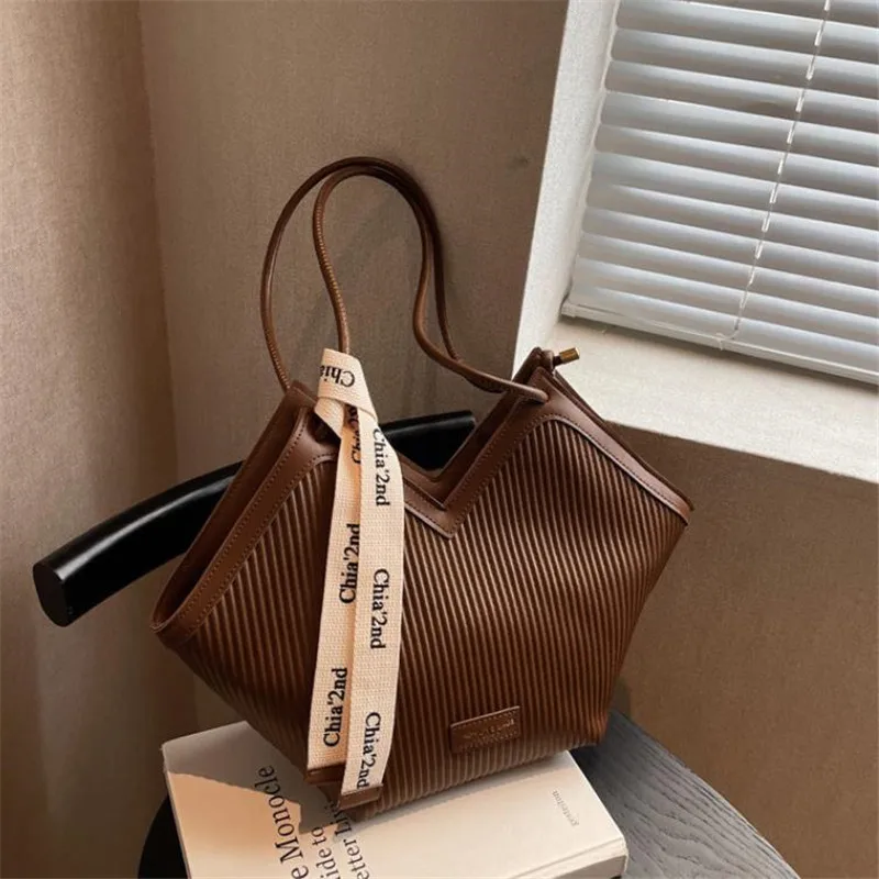 Comparison of faux leather tote with a genuine leather briefcase showing durability differences